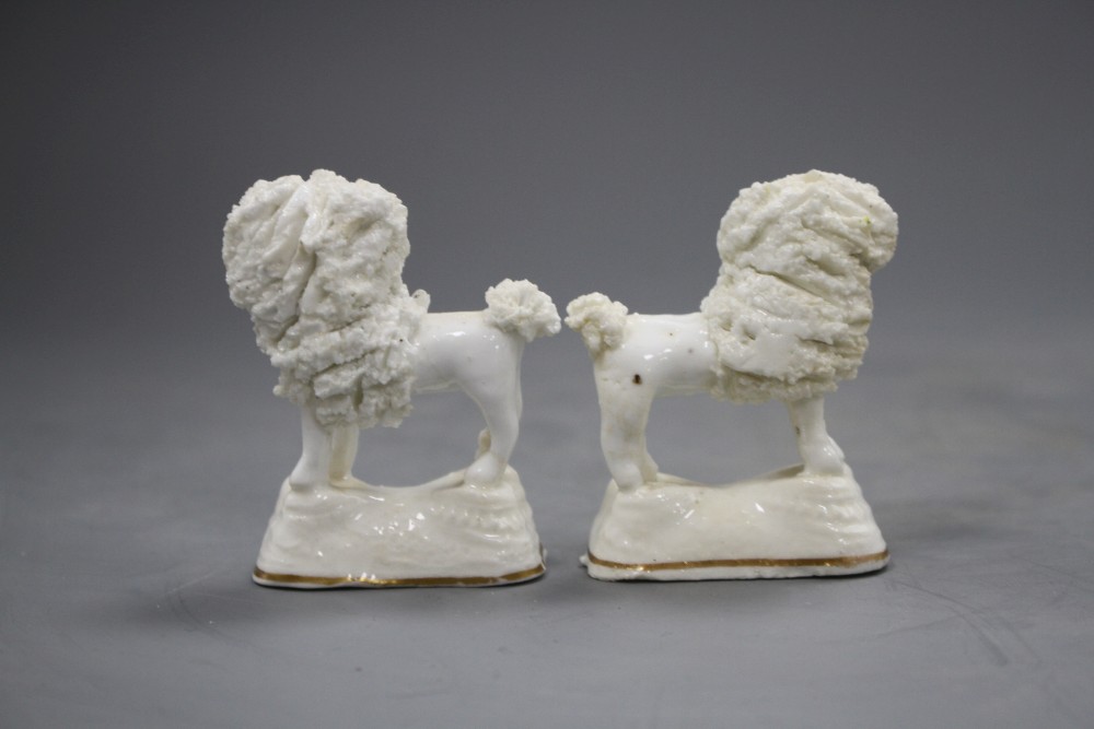 A pair of Staffordshire porcelain models of a poodle with a basket in its mouth, C.1835-50, H. 6.5cm